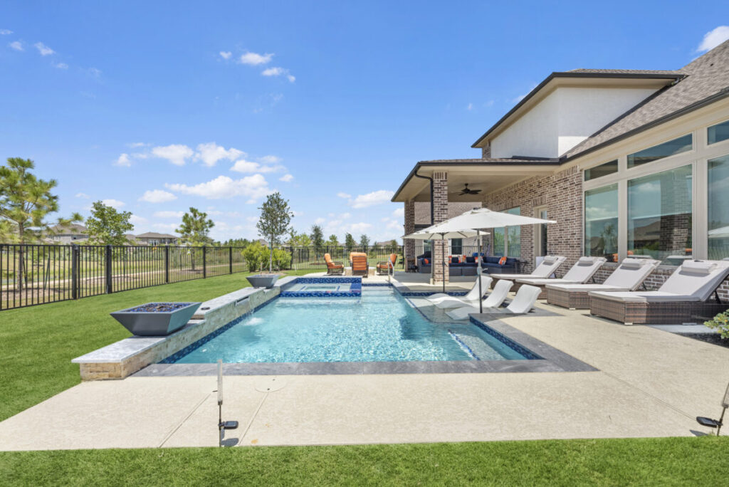 Cypress Project - Blue Wood - Geometric pool, tanning ledge, spa, safety railing, raised back wall, two fire bowls, one scupper, gas fire pit, multi-colored glass beads, travertine topper, split-face siding, glass tile, Arizona Sugar spray decking