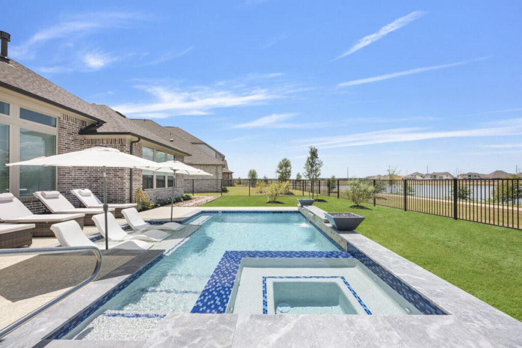 Cypress Project - Blue Wood - Geometric pool, tanning ledge, spa, safety railing, raised back wall, two fire bowls, one scupper, gas fire pit, multi-colored glass beads, travertine topper, split-face siding, glass tile, Arizona Sugar spray decking