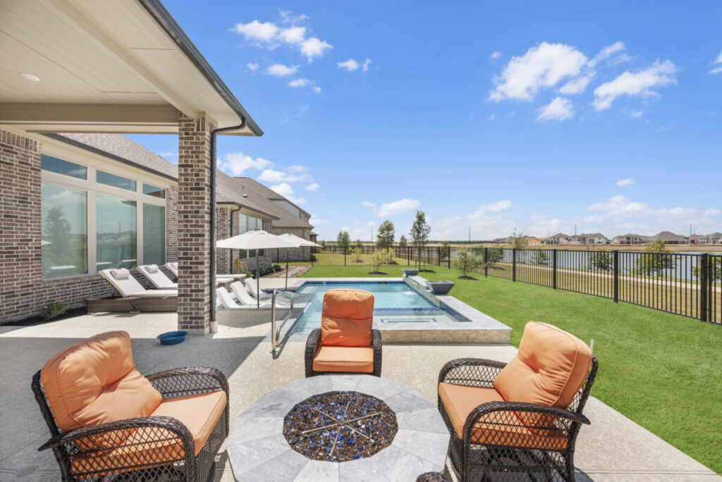 Cypress Project - Blue Wood - Geometric pool, tanning ledge, spa, safety railing, raised back wall, two fire bowls, one scupper, gas fire pit, multi-colored glass beads, travertine topper, split-face siding, glass tile, Arizona Sugar spray decking