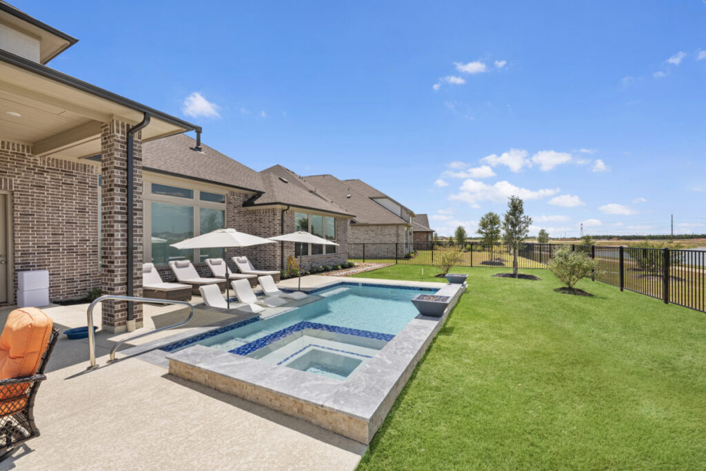 Cypress Project - Blue Wood - Geometric pool, tanning ledge, spa, safety railing, raised back wall, two fire bowls, one scupper, gas fire pit, multi-colored glass beads, travertine topper, split-face siding, glass tile, Arizona Sugar spray decking