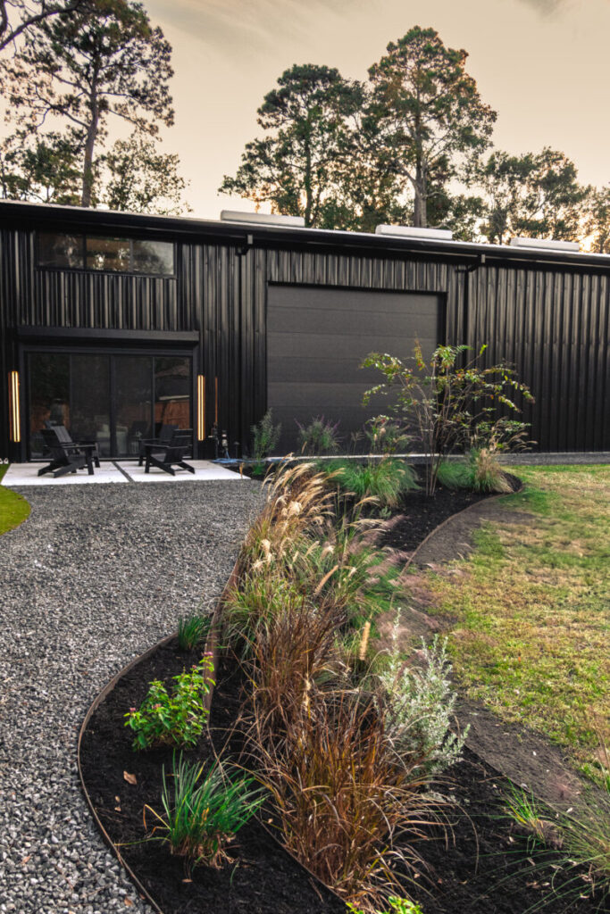 Houston Project - Acorn Ln - hardscaping, poured-in-place concrete pavers, black star gravel walkway, raised metal borders, artificial turf, low maintenance plants