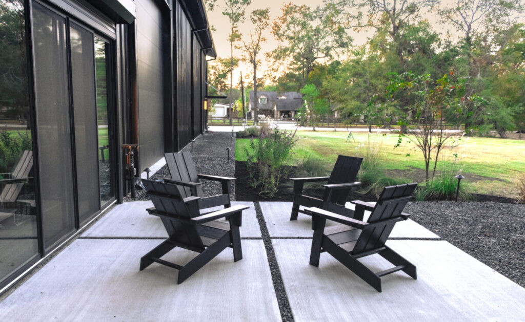Houston Project - Acorn Ln - hardscaping, poured-in-place concrete pavers, black star gravel walkway, raised metal borders, artificial turf, low maintenance plants