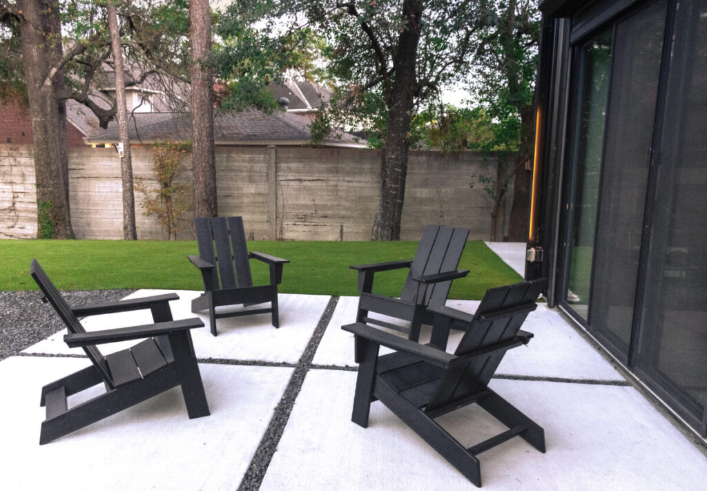 Houston Project - Acorn Ln - hardscaping, poured-in-place concrete pavers, black star gravel walkway, raised metal borders, artificial turf, low maintenance plants