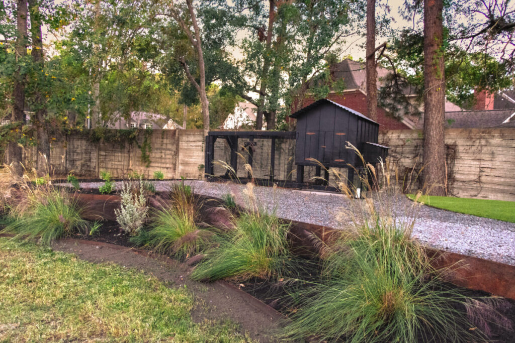 Houston Project - Acorn Ln - hardscaping, poured-in-place concrete pavers, black star gravel walkway, raised metal borders, artificial turf, low maintenance plants