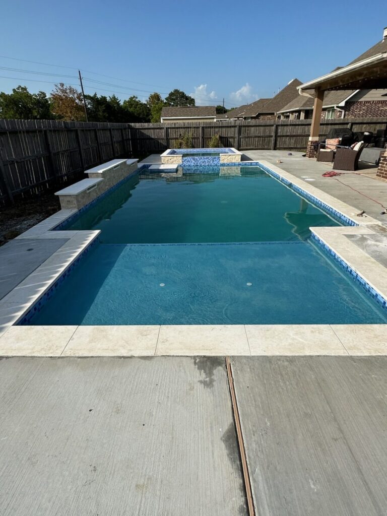 Mont Belvieu - Champions Gate - Geometric pool, raised spa, tanning ledge, water features - three scuppers and two bubblers, travertine coping, glass tile, pool table with travertine topper, raised backwall, spray decking, StoneScapes plaster