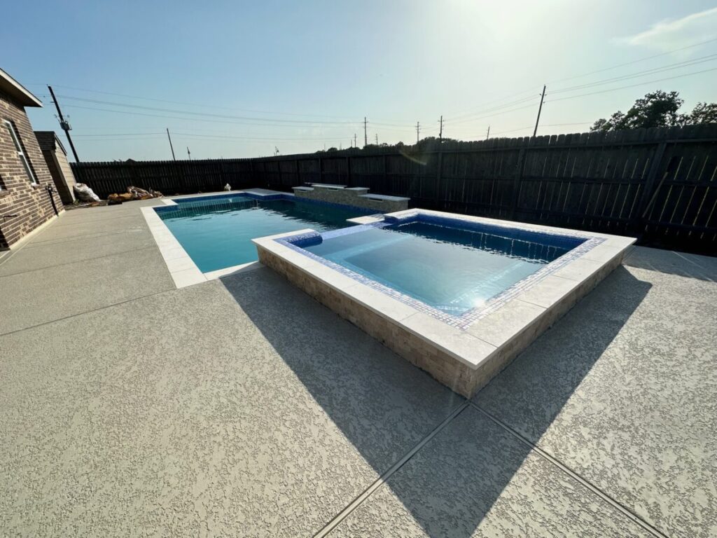Mont Belvieu - Champions Gate - Geometric pool, raised spa, tanning ledge, water features - three scuppers and two bubblers, travertine coping, glass tile, pool table with travertine topper, raised backwall, spray decking, StoneScapes plaster