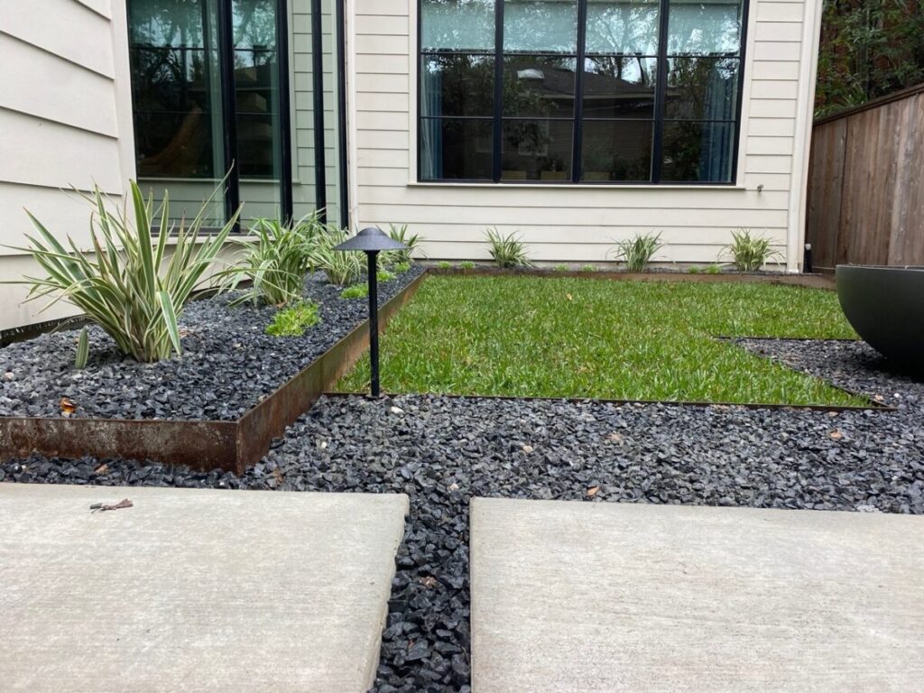 Heights Project Banks St - Poured-in-place concrete pavers, hardscaping, landscaping, Little Gem magnolia,, bamboo 'Graceful', Japanese yew, flax lily, black star gravel, white gravel, landscape uplights, Mexican heather, variegated liriope, sweet alyssum, metal planter, seasonal flowers, metal border built in-house, welded on-site, elegant white precast firepit