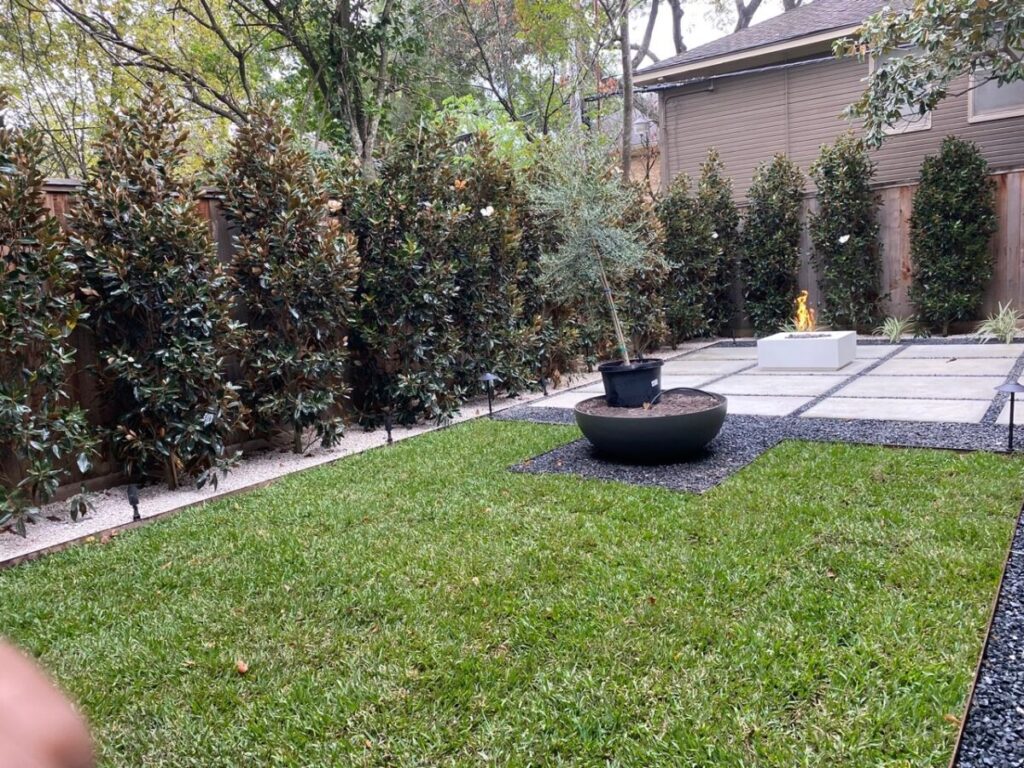 Heights Project Banks St - Poured-in-place concrete pavers, hardscaping, landscaping, Little Gem magnolia,, bamboo 'Graceful', Japanese yew, flax lily, black star gravel, white gravel, landscape uplights, Mexican heather, variegated liriope, sweet alyssum, metal planter, seasonal flowers, metal border built in-house, welded on-site, elegant white precast firepit