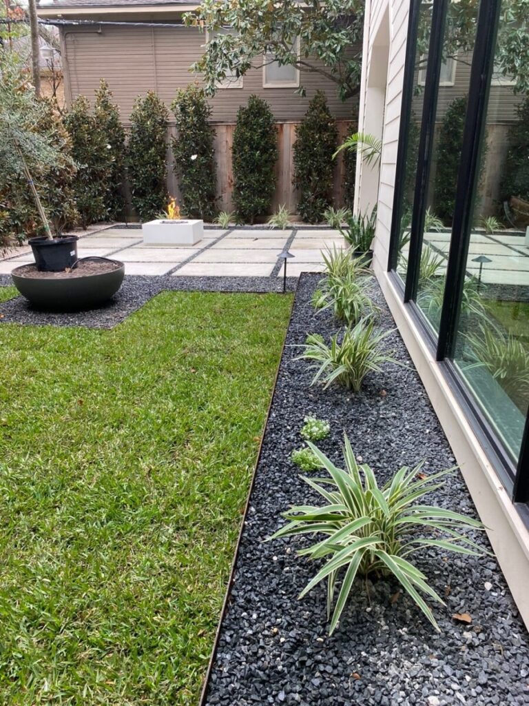 Heights Project Banks St - Poured-in-place concrete pavers, hardscaping, landscaping, Little Gem magnolia,, bamboo 'Graceful', Japanese yew, flax lily, black star gravel, white gravel, landscape uplights, Mexican heather, variegated liriope, sweet alyssum, metal planter, seasonal flowers, metal border built in-house, welded on-site, elegant white precast firepit