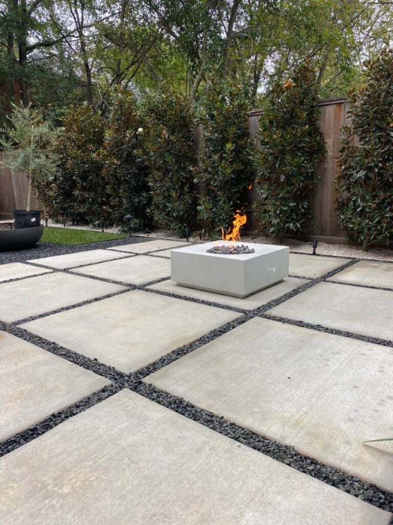 Heights Project Banks St - Poured-in-place concrete pavers, hardscaping, landscaping, Little Gem magnolia,, bamboo 'Graceful', Japanese yew, flax lily, black star gravel, white gravel, landscape uplights, Mexican heather, variegated liriope, sweet alyssum, metal planter, seasonal flowers, metal border built in-house, welded on-site, elegant white precast firepit