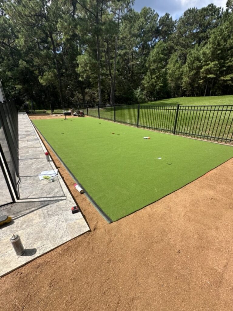 Magnolia Ranch Project - Roman-style pool with infinity edge spa, pillow-top edge, water features – three bubblers, six deck jets, French pattern travertine decking, chipping mat, artificial turf with putting green, accent boulders