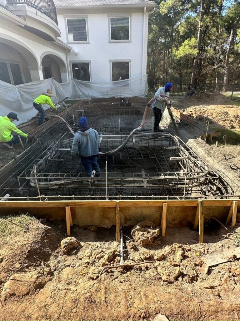 Magnolia Ranch Project - Roman-style pool with infinity edge spa, pillow-top edge, water features – three bubblers, six deck jets, French pattern travertine decking, chipping mat, artificial turf with putting green, accent boulders