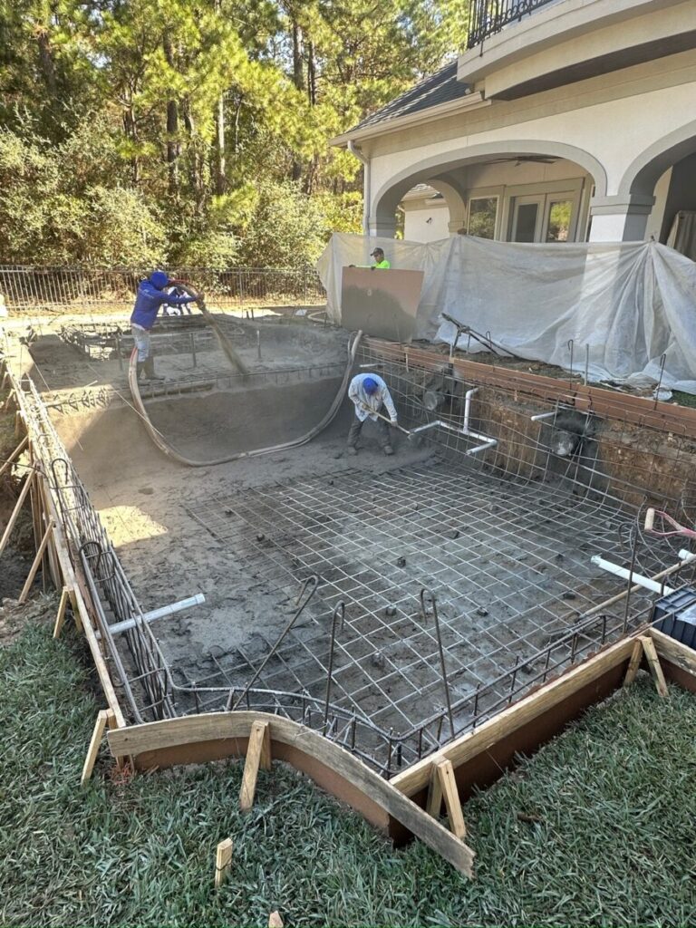 Magnolia Ranch Project - Roman-style pool with infinity edge spa, pillow-top edge, water features – three bubblers, six deck jets, French pattern travertine decking, chipping mat, artificial turf with putting green, accent boulders