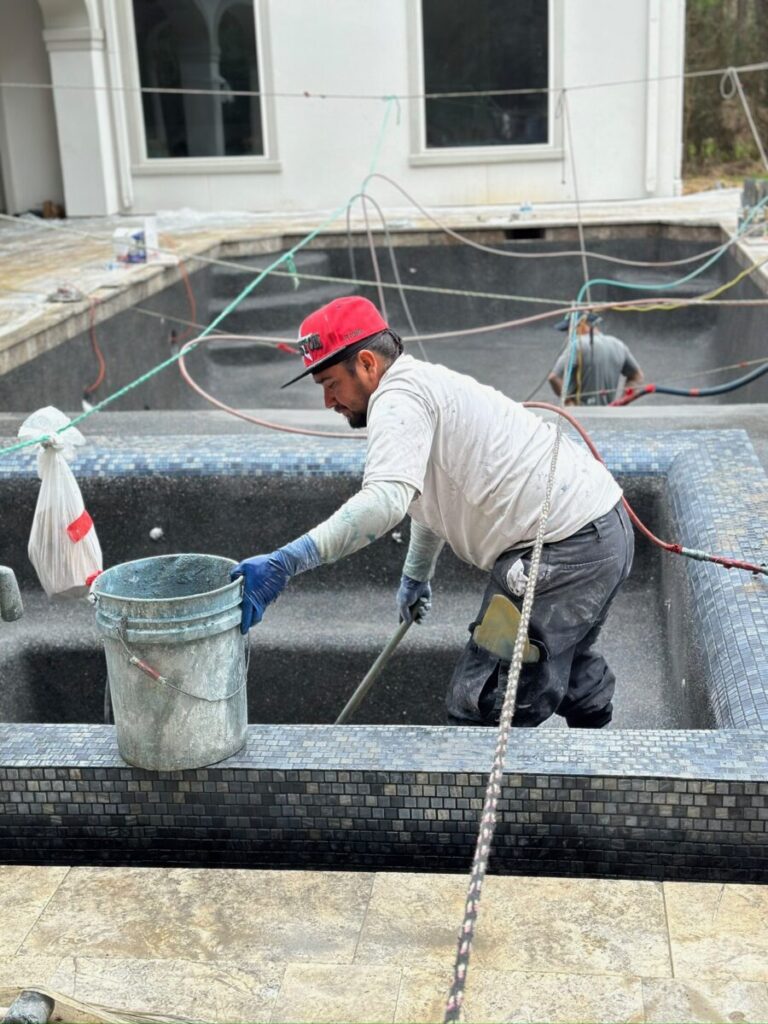Magnolia Ranch Project - Roman-style pool with infinity edge spa, pillow-top edge, water features – three bubblers, six deck jets, French pattern travertine decking, chipping mat, artificial turf with putting green, accent boulders