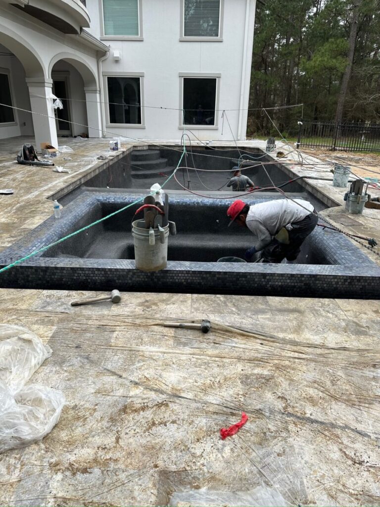 Magnolia Ranch Project - Roman-style pool with infinity edge spa, pillow-top edge, water features – three bubblers, six deck jets, French pattern travertine decking, chipping mat, artificial turf with putting green, accent boulders