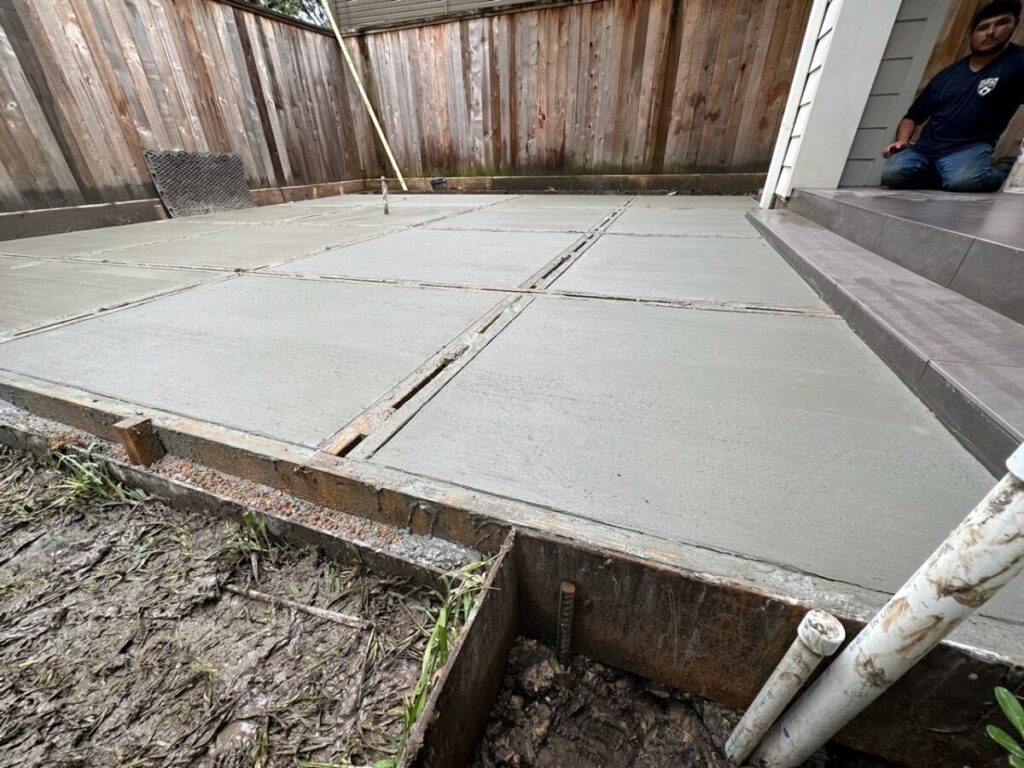 Heights Project Banks St - Poured-in-place concrete pavers, hardscaping, landscaping, Little Gem magnolia,, bamboo 'Graceful', Japanese yew, flax lily, black star gravel, white gravel, landscape uplights, Mexican heather, variegated liriope, sweet alyssum, metal planter, seasonal flowers, metal border built in-house, welded on-site, elegant white precast firepit