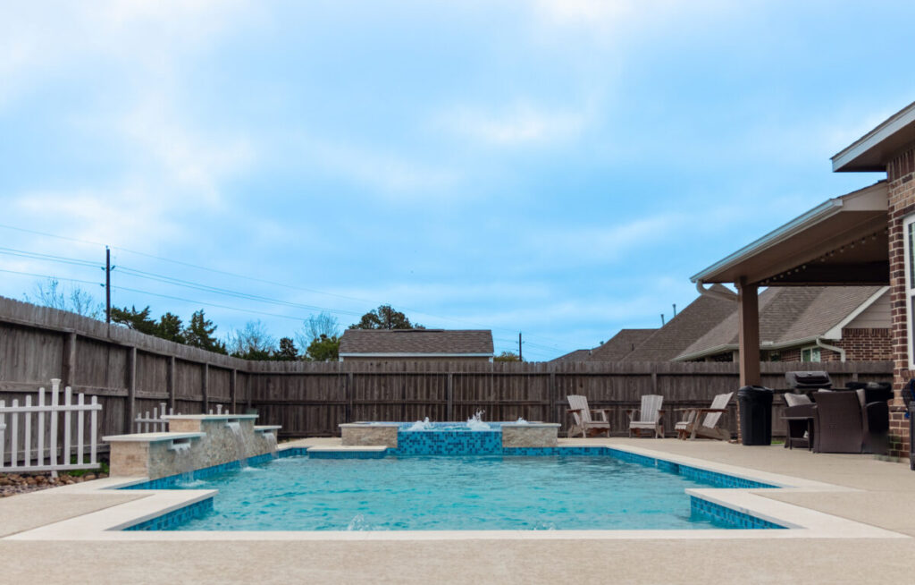 Mont Belvieu - Champions Gate - Geometric pool, raised spa, tanning ledge, water features - three scuppers and two bubblers, travertine coping, glass tile, pool table with travertine topper, raised backwall, spray decking, StoneScapes plaster