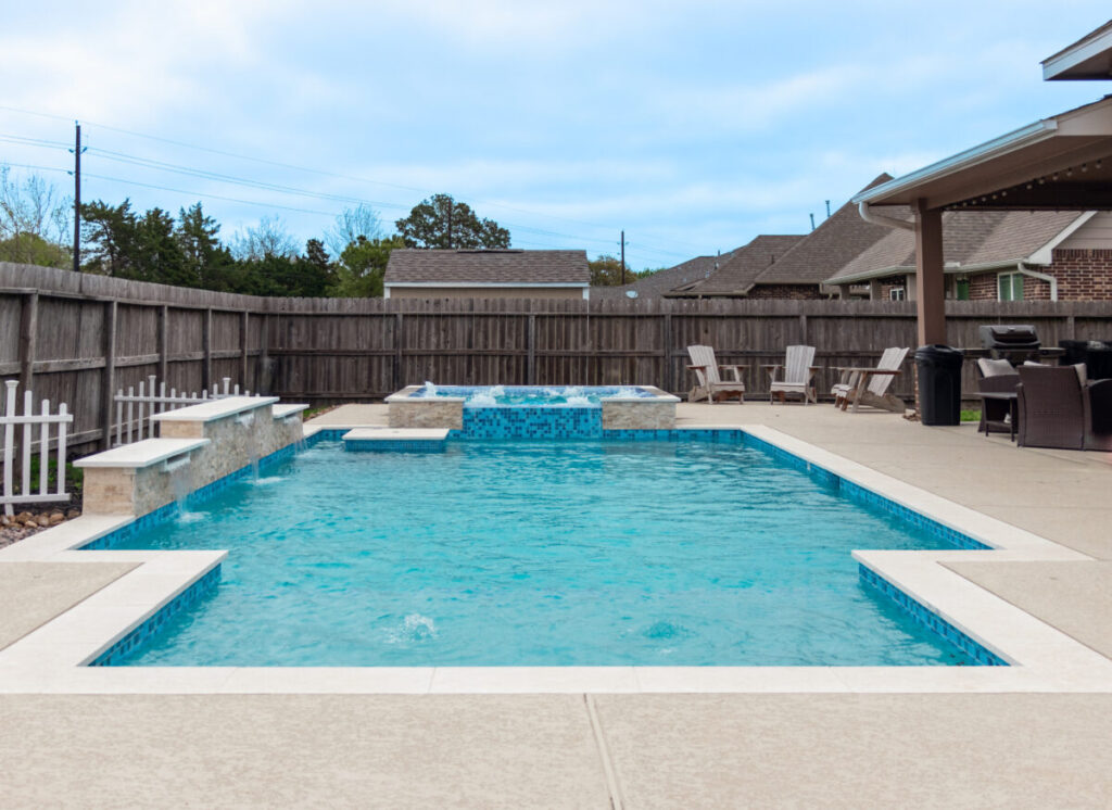 Mont Belvieu - Champions Gate - Geometric pool, raised spa, tanning ledge, water features - three scuppers and two bubblers, travertine coping, glass tile, pool table with travertine topper, raised backwall, spray decking, StoneScapes plaster