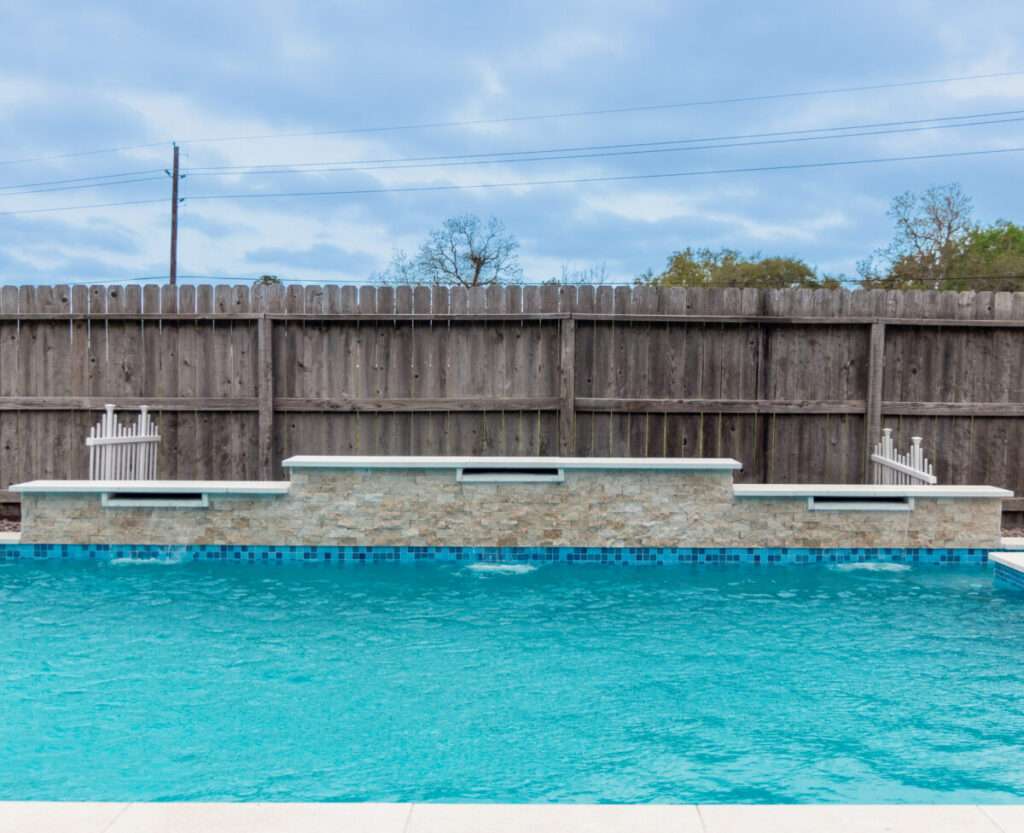 Mont Belvieu - Champions Gate - Geometric pool, raised spa, tanning ledge, water features - three scuppers and two bubblers, travertine coping, glass tile, pool table with travertine topper, raised backwall, spray decking, StoneScapes plaster