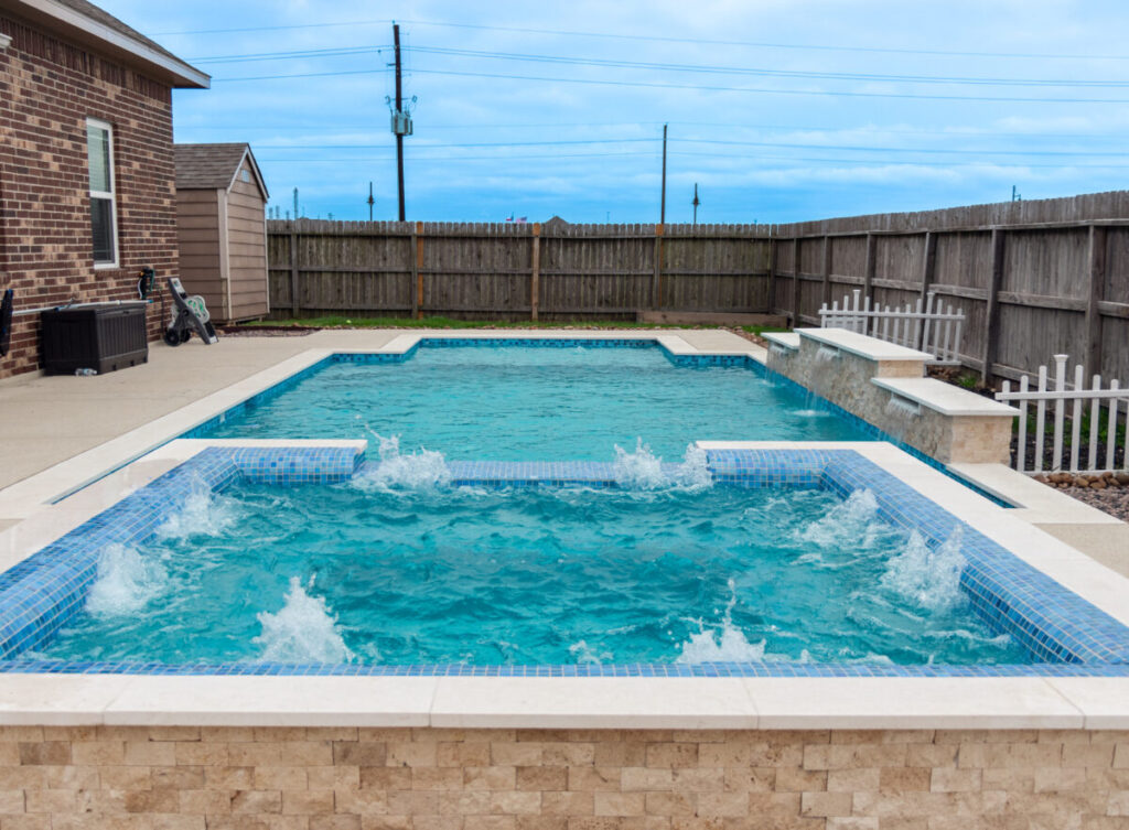 Mont Belvieu - Champions Gate - Geometric pool, raised spa, tanning ledge, water features - three scuppers and two bubblers, travertine coping, glass tile, pool table with travertine topper, raised backwall, spray decking, StoneScapes plaster