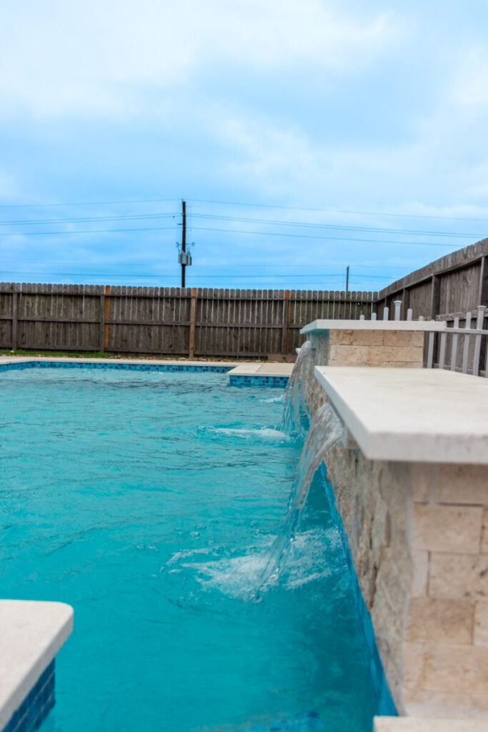 Mont Belvieu - Champions Gate - Geometric pool, raised spa, tanning ledge, water features - three scuppers and two bubblers, travertine coping, glass tile, pool table with travertine topper, raised backwall, spray decking, StoneScapes plaster