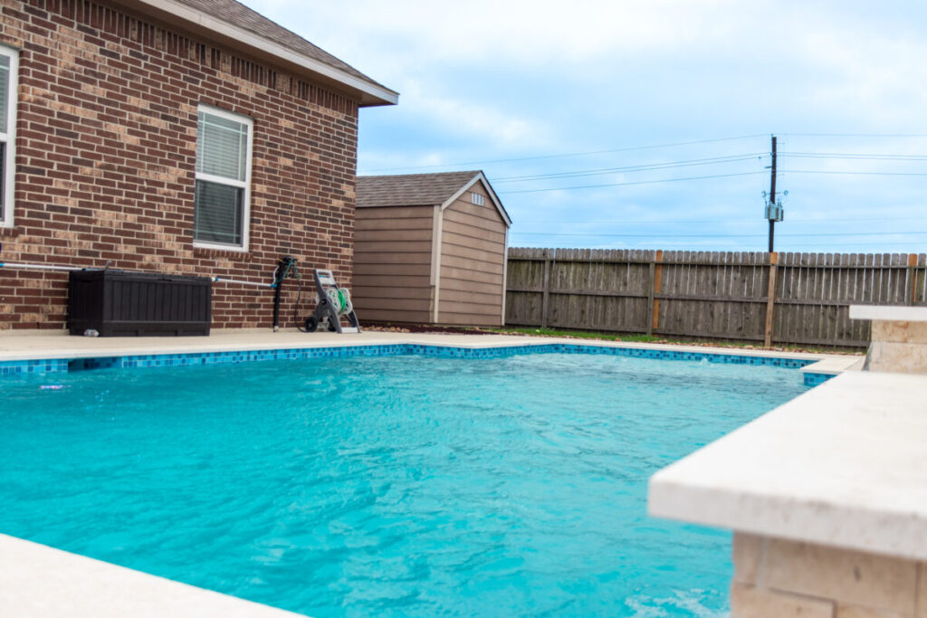 Mont Belvieu - Champions Gate - Geometric pool, raised spa, tanning ledge, water features - three scuppers and two bubblers, travertine coping, glass tile, pool table with travertine topper, raised backwall, spray decking, StoneScapes plaster
