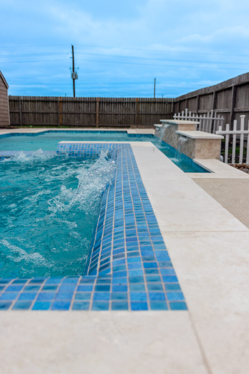 Leak Detection Mont Belvieu - Champions Gate - Geometric pool, raised spa, tanning ledge, water features - three scuppers and two bubblers, travertine coping, glass tile, pool table with travertine topper, raised backwall, spray decking, StoneScapes plaster