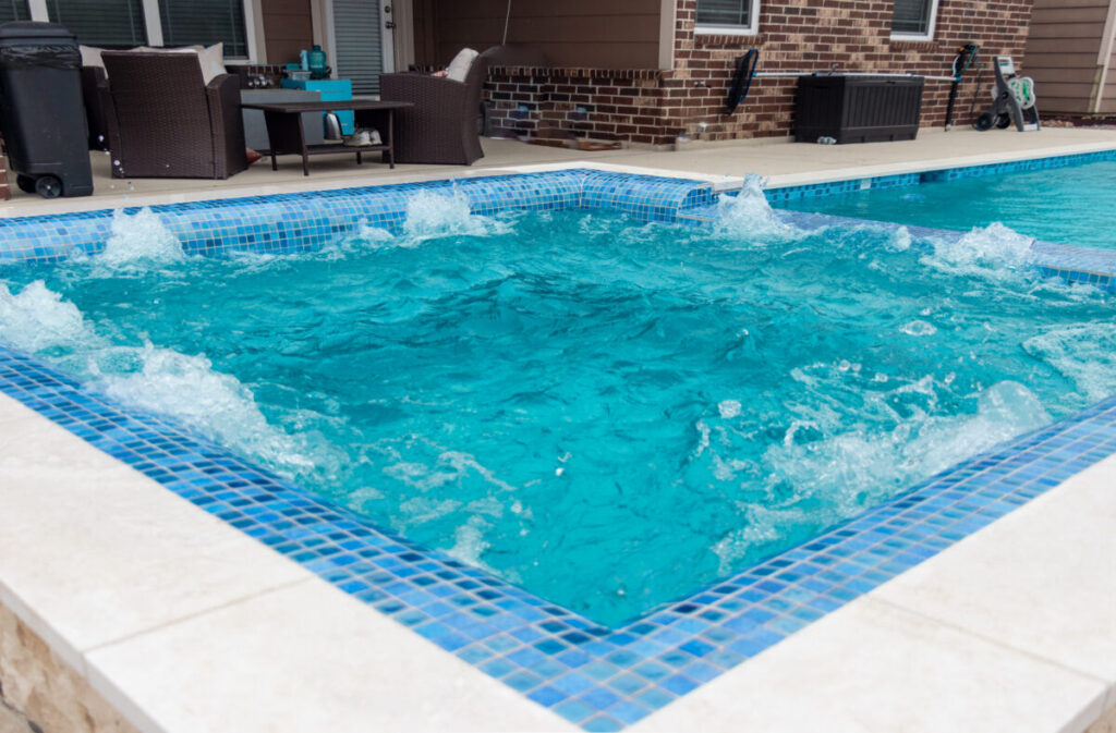 Mont Belvieu - Champions Gate - Geometric pool, raised spa, tanning ledge, water features - three scuppers and two bubblers, travertine coping, glass tile, pool table with travertine topper, raised backwall, spray decking, StoneScapes plaster