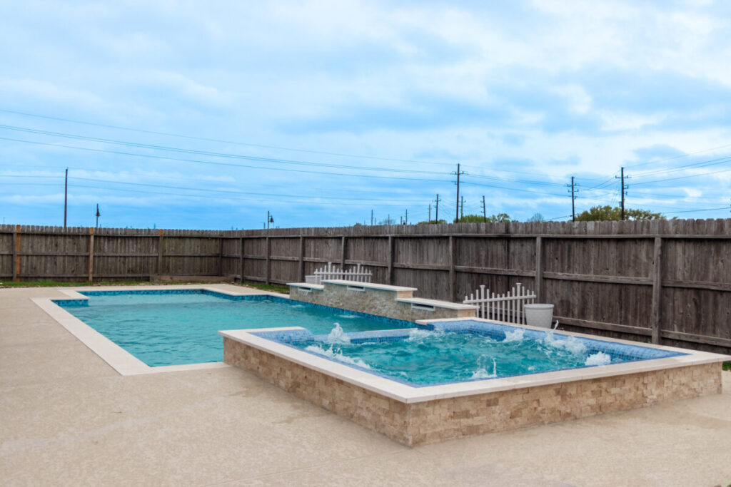 Mont Belvieu - Champions Gate - Geometric pool, raised spa, tanning ledge, water features - three scuppers and two bubblers, travertine coping, glass tile, pool table with travertine topper, raised backwall, spray decking, StoneScapes plaster