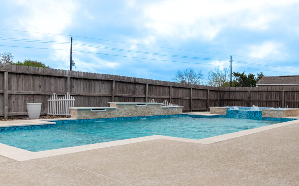 Mont Belvieu - Champions Gate - Geometric pool, raised spa, tanning ledge, water features - three scuppers and two bubblers, travertine coping, glass tile, pool table with travertine topper, raised backwall, spray decking, StoneScapes plaster