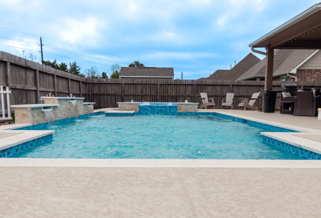 Mont Belvieu - Champions Gate - Geometric pool, raised spa, tanning ledge, water features - three scuppers and two bubblers, travertine coping, glass tile, pool table with travertine topper, raised backwall, spray decking, StoneScapes plaster