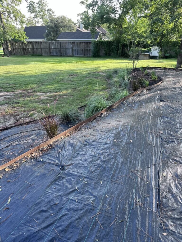 Houston Project - Acorn Ln - hardscaping, poured-in-place concrete pavers, black star gravel walkway, raised metal borders, artificial turf, low maintenance plants