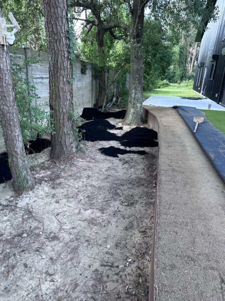 Houston Project - Acorn Ln - hardscaping, poured-in-place concrete pavers, black star gravel walkway, raised metal borders, artificial turf, low maintenance plants