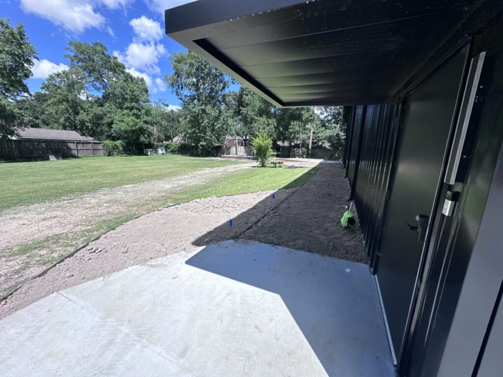 Houston Project - Acorn Ln - hardscaping, poured-in-place concrete pavers, black star gravel walkway, raised metal borders, artificial turf, low maintenance plants