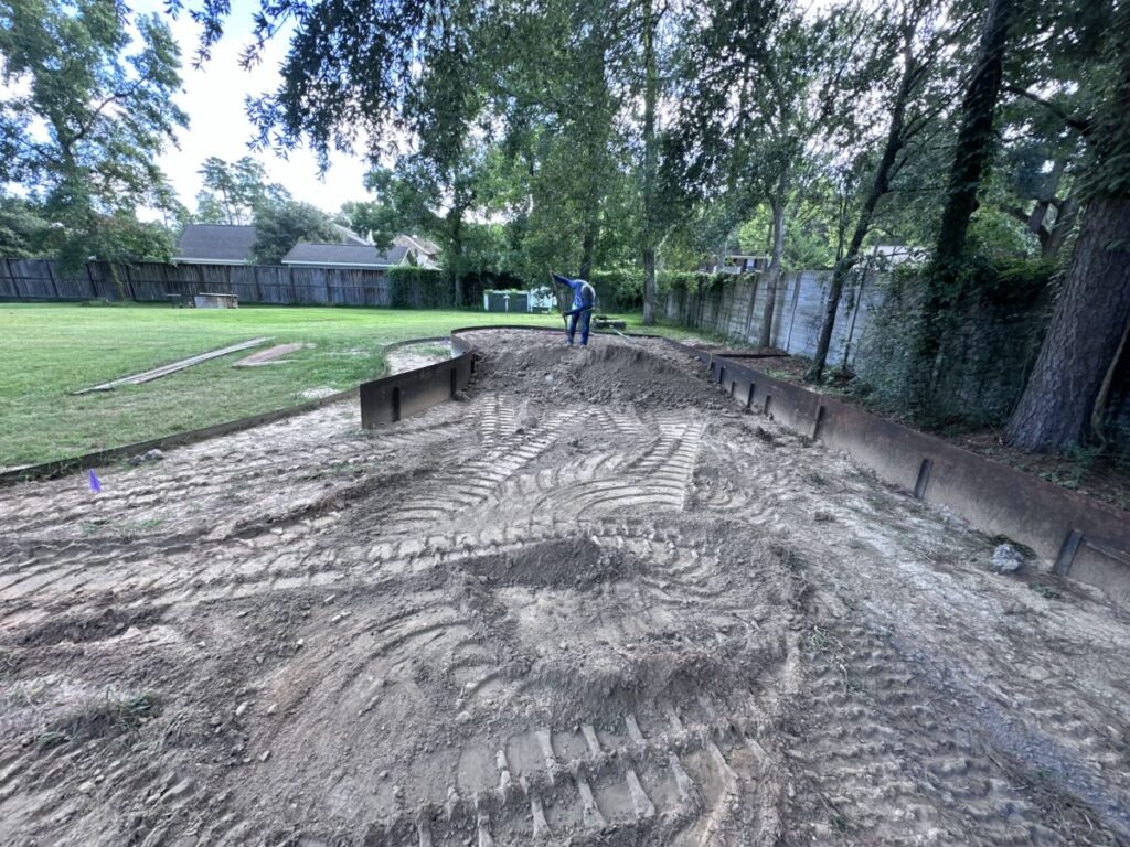 Houston Project - Acorn Ln - hardscaping, poured-in-place concrete pavers, black star gravel walkway, raised metal borders, artificial turf, low maintenance plants
