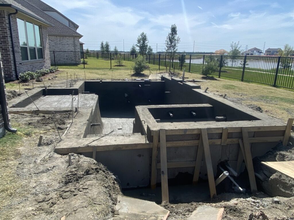 Cypress Project - Blue Wood - Geometric pool, tanning ledge, spa, safety railing, raised back wall, two fire bowls, one scupper, gas fire pit, multi-colored glass beads, travertine topper, split-face siding, glass tile, Arizona Sugar spray decking