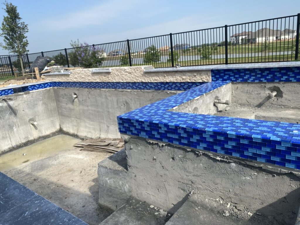 Cypress Project - Blue Wood - Geometric pool, tanning ledge, spa, safety railing, raised back wall, two fire bowls, one scupper, gas fire pit, multi-colored glass beads, travertine topper, split-face siding, glass tile, Arizona Sugar spray decking