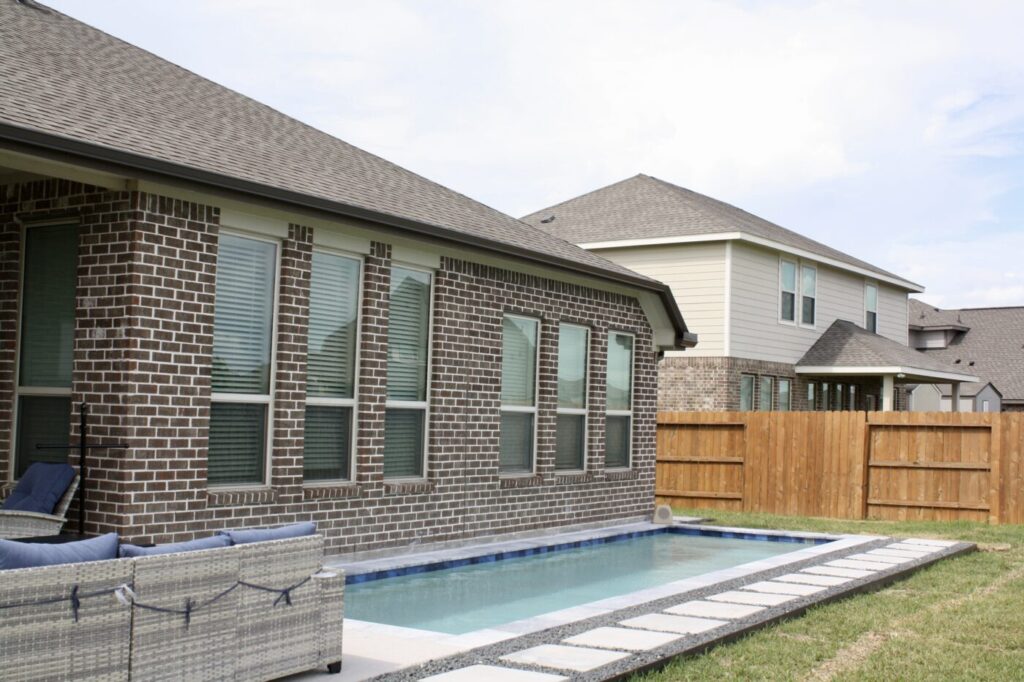 Texas Turf Tenders installed a geometric lap pool with a clean 6×6 tile finish. Spray decking offers a safe, polished surface, while a custom turf putting green adds a playful and personal touch.