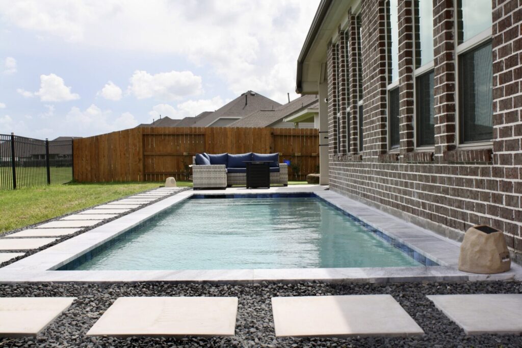 Texas Turf Tenders installed a geometric lap pool with a clean 6×6 tile finish. Spray decking offers a safe, polished surface, while a custom turf putting green finishes the minimal backyard makeover.