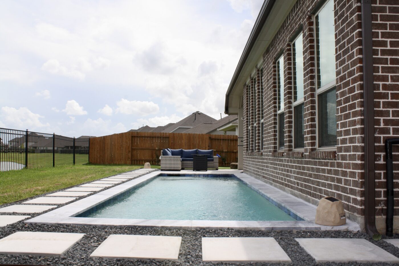 Texas Turf Tenders installed a geometric lap pool with a clean 6×6 tile finish. Spray decking offers a safe, polished surface, while a custom turf putting green finishes the minimal backyard makeover.