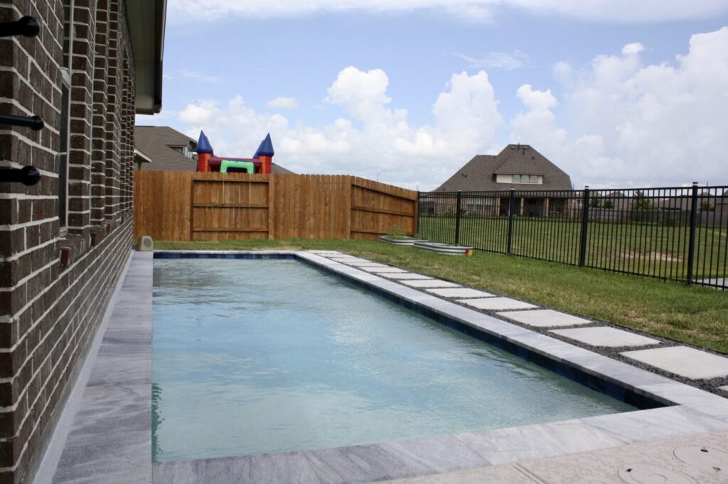 Texas Turf Tenders installed a geometric lap pool with a clean 6×6 tile finish. Spray decking offers a safe, polished surface, while a custom turf putting green finishes the minimal backyard makeover.