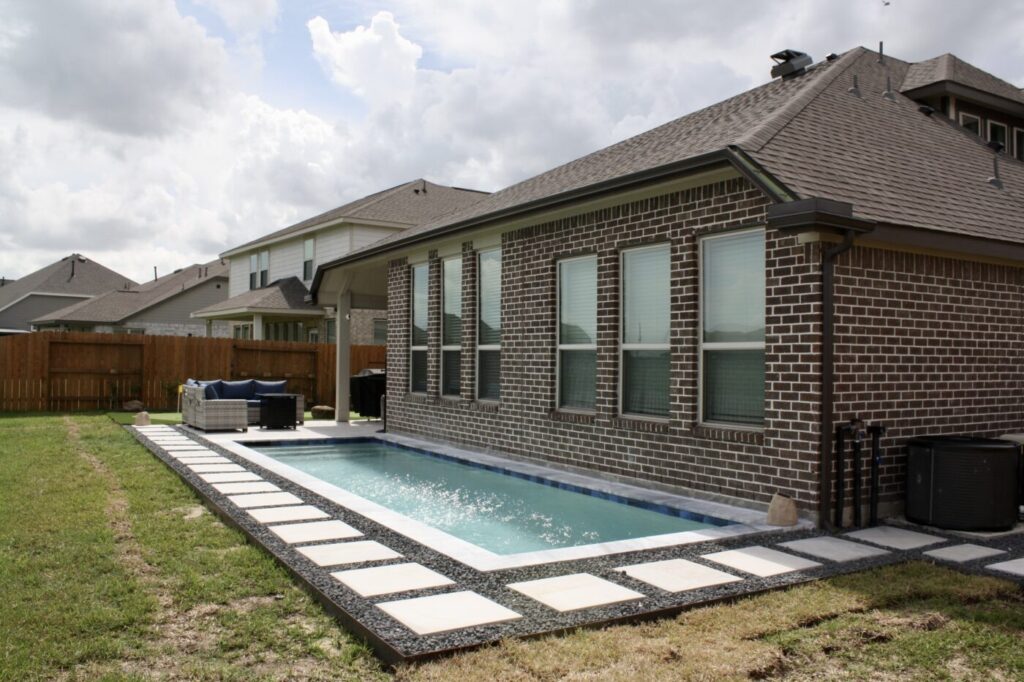 Texas Turf Tenders installed a geometric lap pool with a clean 6×6 tile finish. Spray decking offers a safe, polished surface, while a custom turf putting green finishes the minimal backyard makeover.