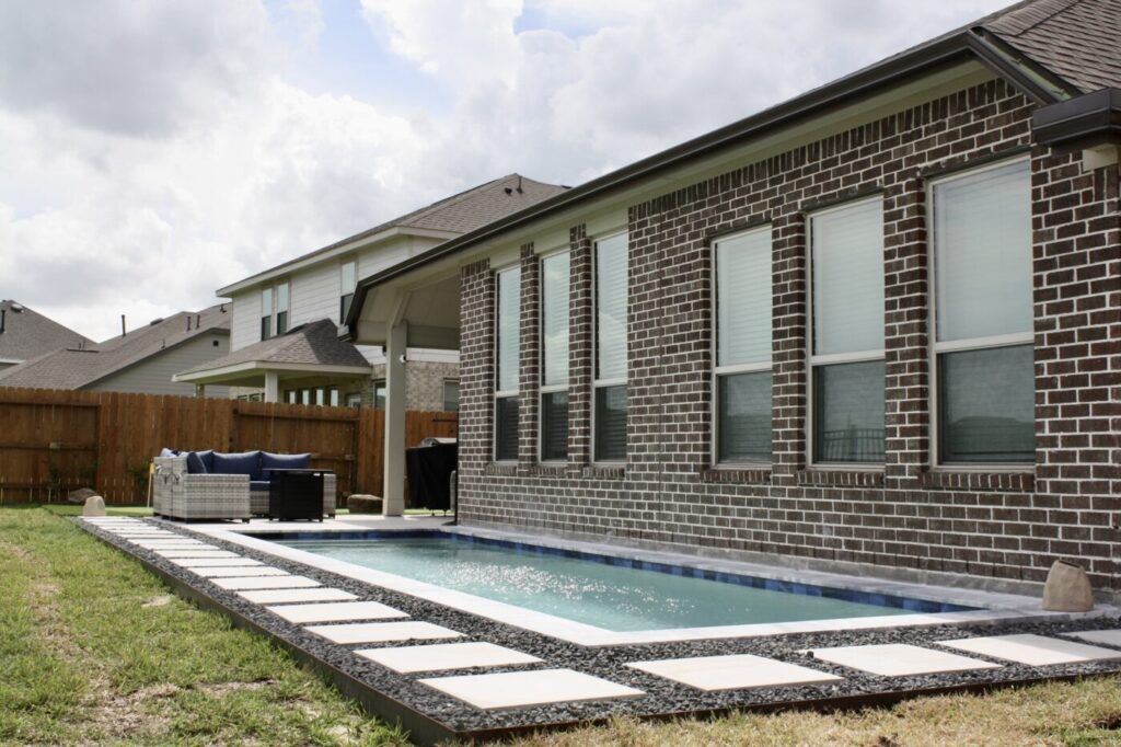 Texas Turf Tenders installed a geometric lap pool with a clean 6×6 tile finish. Spray decking offers a safe, polished surface, while a custom turf putting green finishes the minimal backyard makeover.